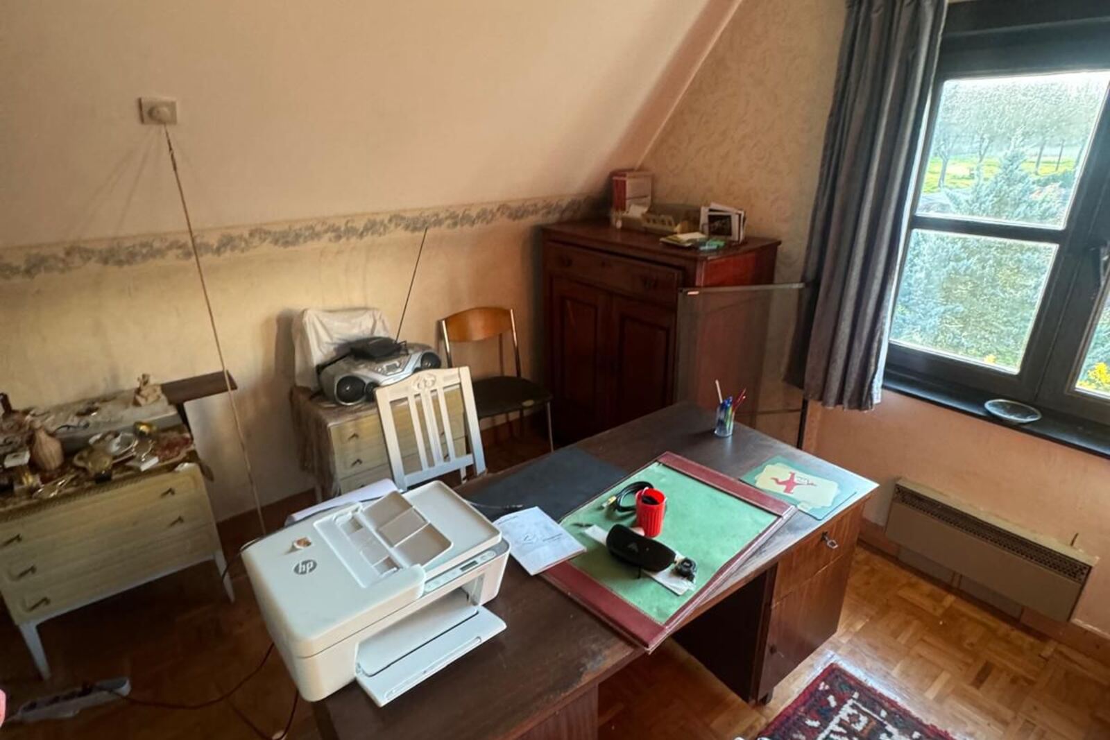 Zolderkamer ingericht als bureau voor het leeghalen